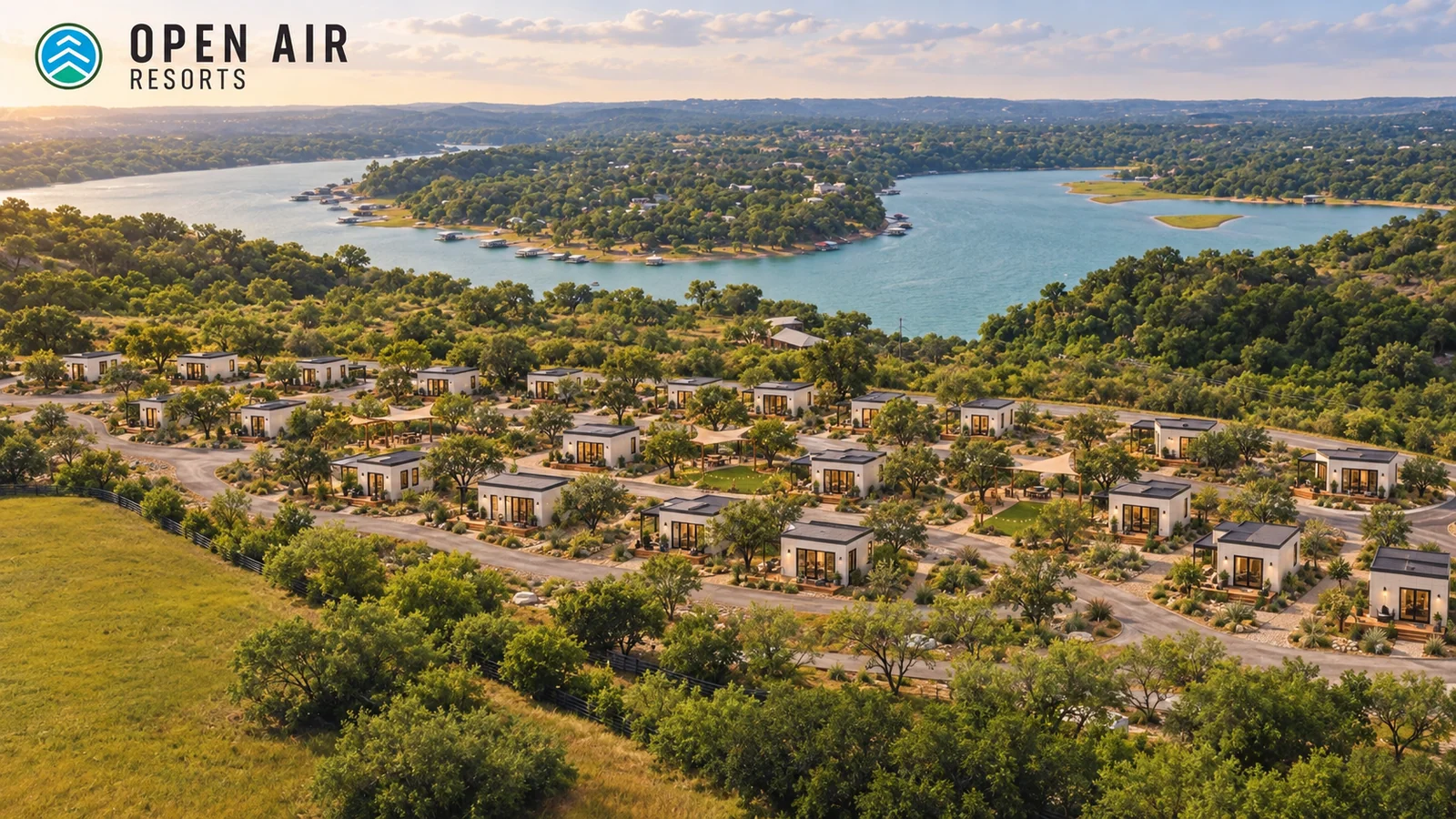 Generated concept rendering of compact modular homes on the Open Air Spicewood site, retaining the lake, trees and campground roads. This village is not built.
